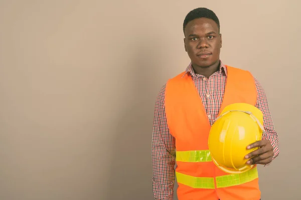 Beyaz arka planda genç Afrikalı inşaat işçisi — Stok fotoğraf