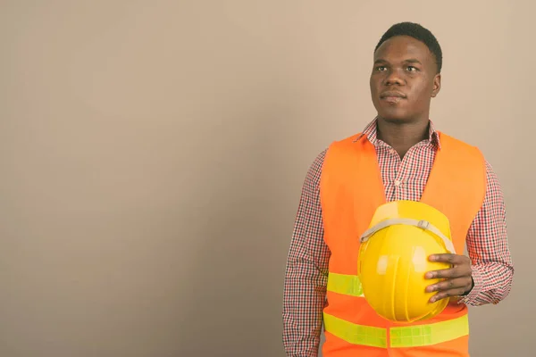 Jovem homem africano trabalhador de construção contra fundo branco — Fotografia de Stock