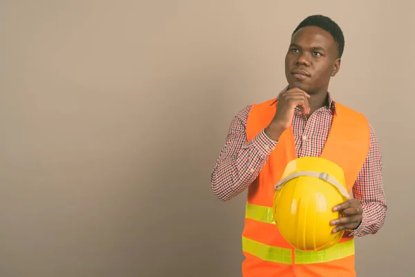 Beyaz arka planda genç Afrikalı inşaat işçisi — Stok fotoğraf
