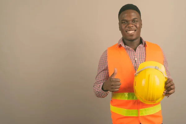 Jonge Afrikaanse man bouwvakker tegen witte achtergrond — Stockfoto