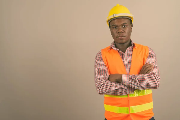 Jovem homem africano trabalhador de construção contra fundo branco — Fotografia de Stock