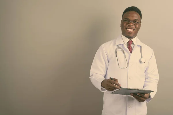 Young African man doctor against white background — Stock Photo, Image