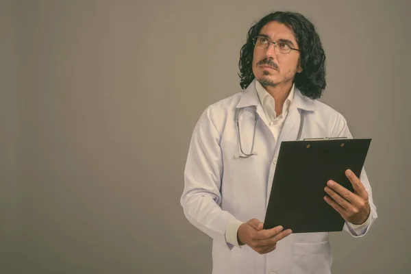 Pohledný muž lékař s knírem na šedém pozadí — Stock fotografie
