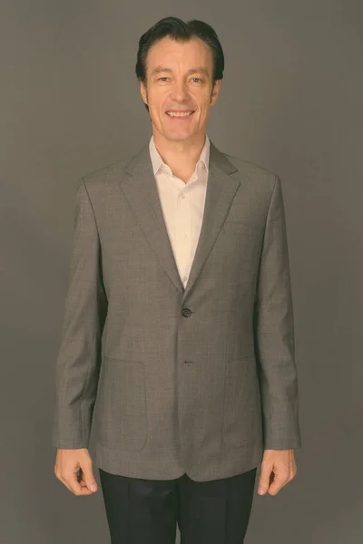 灰色の背景を持つ成熟したハンサムなビジネスマン — ストック写真