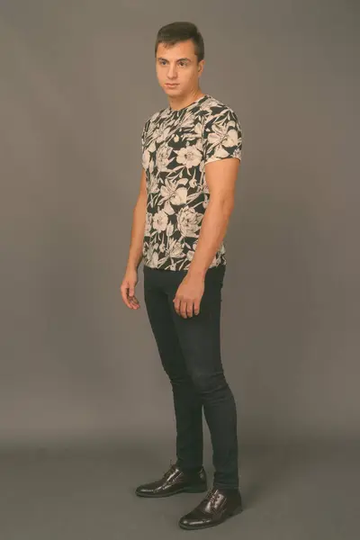 Studio shot of young handsome man against gray background — Stock Photo, Image