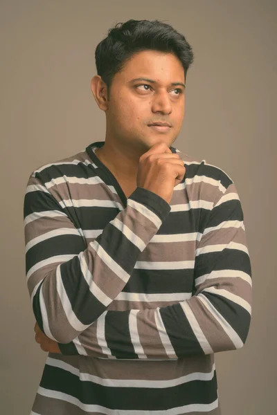 Retrato de un joven guapo hombre indio sobre fondo de estudio llano —  Fotos de Stock