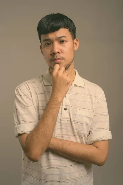 Retrato de joven asiático sobre fondo gris —  Fotos de Stock