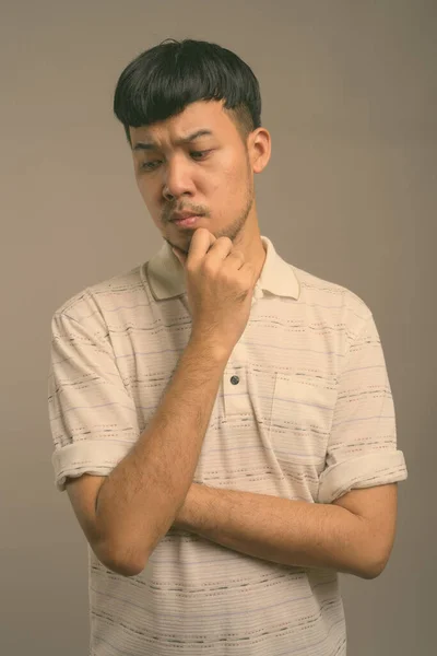 Ritratto di giovane asiatico su sfondo grigio — Foto Stock