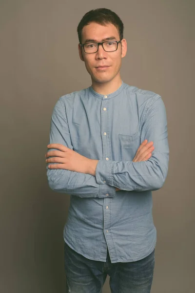 Молодий азіатський бізнесмен проти сірого походження — стокове фото