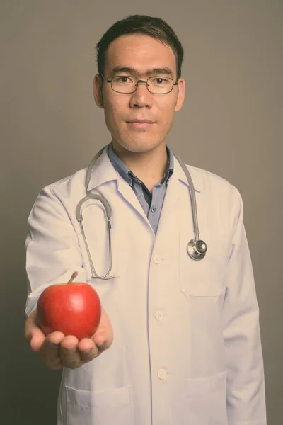 Gri arka planda genç Asyalı doktor — Stok fotoğraf