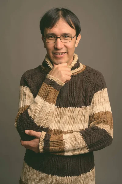 Young Asian nerd man wearing turtleneck sweater against gray background — Stock Photo, Image