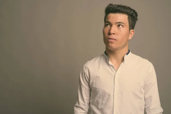 Ung asiatisk affärsman mot grå bakgrund — Stockfoto