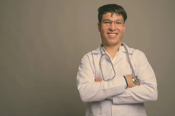 Pemuda Asia dokter terhadap latar belakang abu-abu — Stok Foto