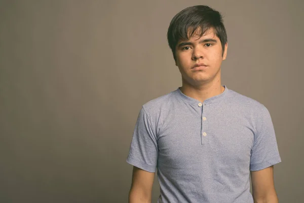 Fiatal ázsiai tinédzser fiú visel kék inget szürke háttér — Stock Fotó