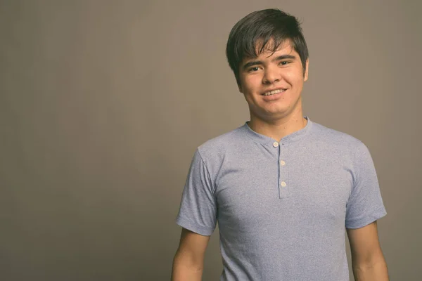 Fiatal ázsiai tinédzser fiú visel kék inget szürke háttér — Stock Fotó