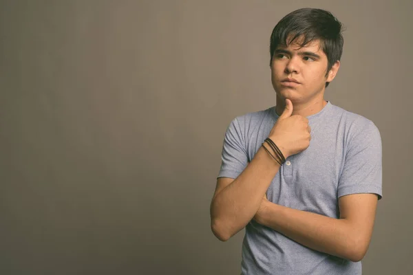 Joven adolescente asiático con camisa azul sobre fondo gris — Foto de Stock