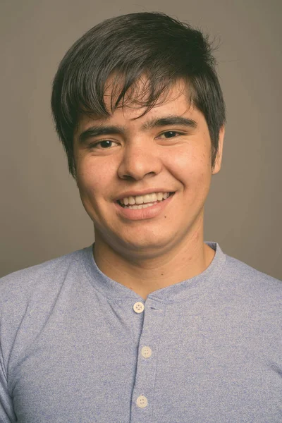 Jovem adolescente asiático vestindo camisa azul contra fundo cinza — Fotografia de Stock