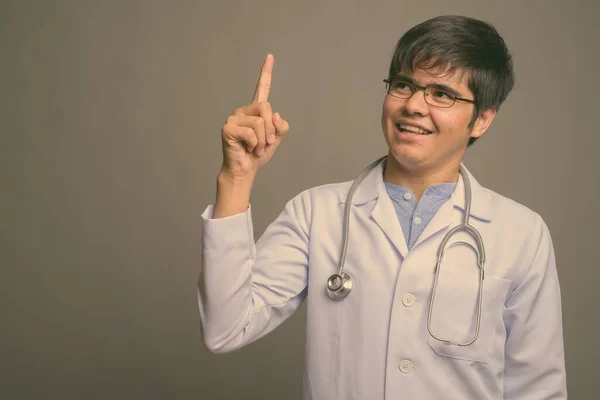 Fiatal ázsiai férfi orvos ellen szürke háttér — Stock Fotó