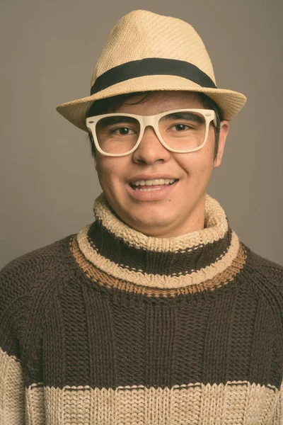 Elegante jovem Asiático adolescente menino vestindo roupas quentes contra fundo cinza — Fotografia de Stock