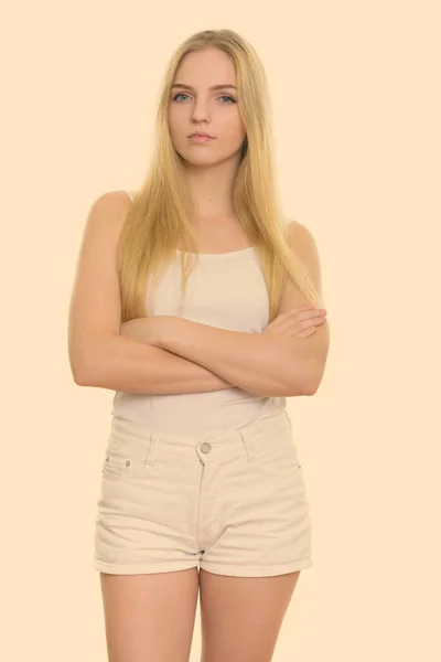 Studio skott av ung vacker tonåring flicka stående med armarna korsade — Stockfoto