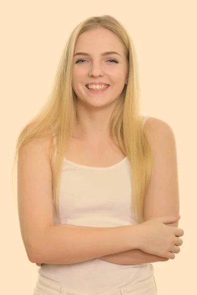 Studio shot van jong gelukkig tienermeisje glimlachen met armen gekruist — Stockfoto