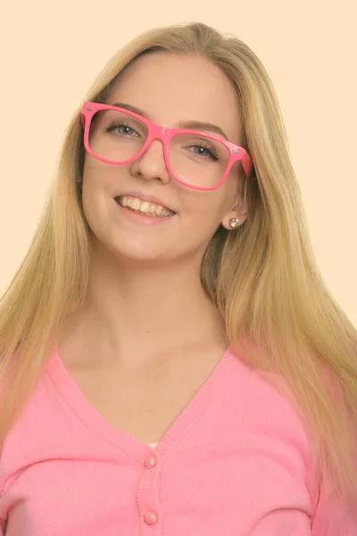 Visage de jeune adolescente heureuse souriante tout en portant des lunettes roses — Photo