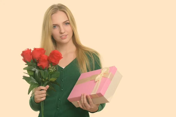 Зйомки молодої прекрасної дівчини-підлітка з червоними трояндами і коробкою з подарунками, готовою до дня Святого Валентина. — стокове фото