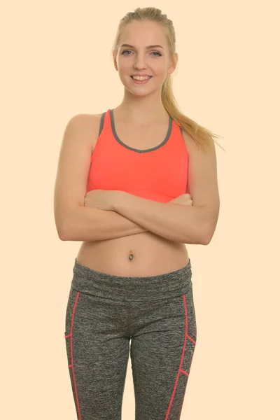 Studio shot de jeune adolescente heureuse souriant avec les bras croisés prêt pour la salle de gym — Photo