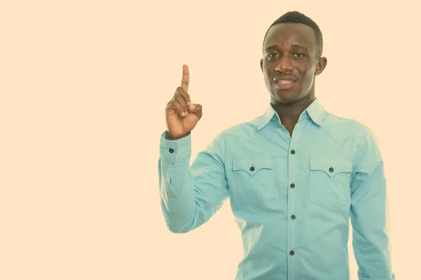 Studio skott av ung glad svart afrikansk man ler samtidigt peka finger upp — Stockfoto