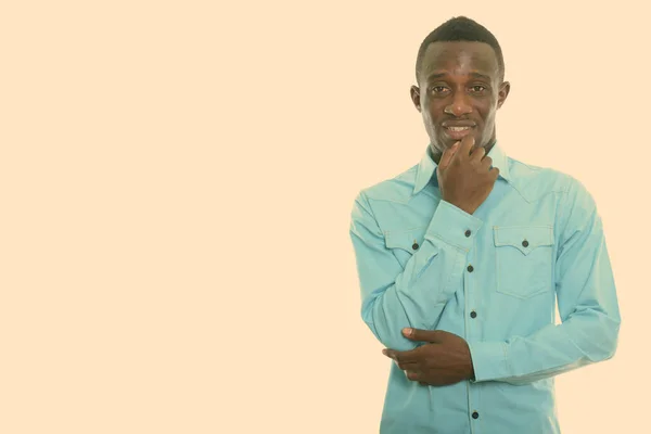 Studio skott av ung glad svart afrikansk man ler samtidigt tänker — Stockfoto