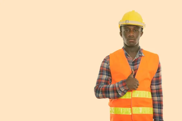 Estúdio tiro de jovem negro africano trabalhador da construção dando polegar para cima — Fotografia de Stock