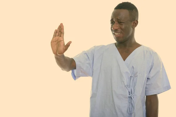 Studio ujęcie młodego czarnego Afrykanina pacjenta wygląda smutno i pokazuje znak stop — Zdjęcie stockowe