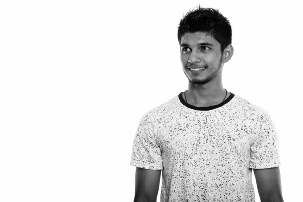 Studioaufnahme eines jungen glücklichen indischen Mannes, der lächelt und nachdenkt, während er nach oben blickt — Stockfoto