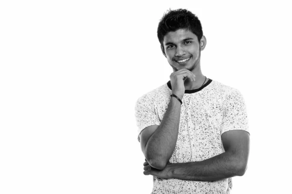 Estúdio tiro de jovem feliz indiano homem sorrindo enquanto pensa — Fotografia de Stock