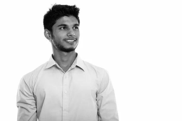 Studioaufnahme eines jungen glücklichen indischen Mannes, der lächelt und nachdenkt, während er nach oben blickt — Stockfoto