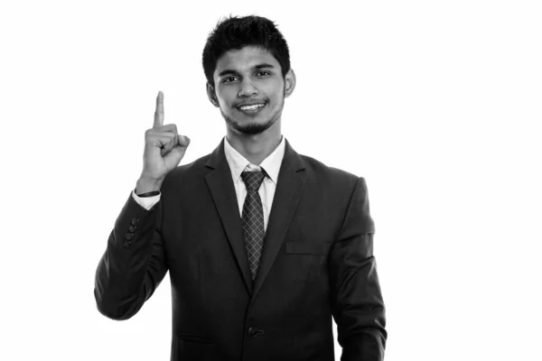 Studio shot de jeune homme d'affaires indien heureux souriant tout en pointant le doigt vers le haut — Photo