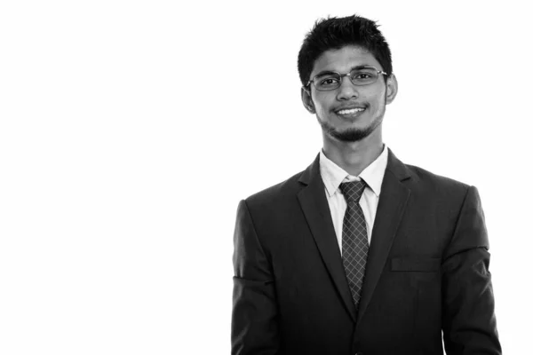 Studio zdjęcia młodego szczęśliwego indyjskiego biznesmena uśmiechającego się w okularach — Zdjęcie stockowe