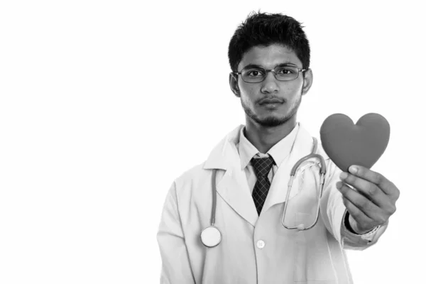 Estudio disparo de joven guapo indio hombre médico sosteniendo corazón rojo —  Fotos de Stock