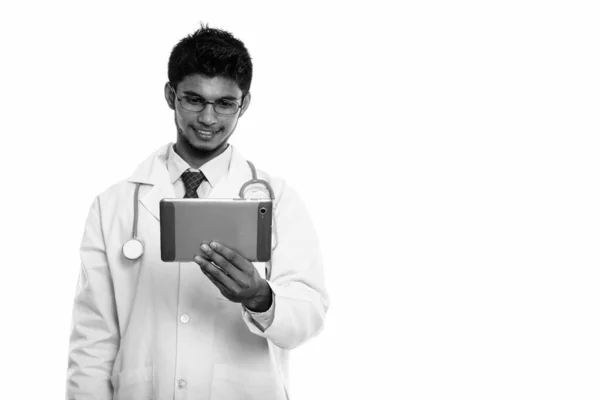 Estudio de tiro de joven feliz indio hombre médico sonriendo mientras sostiene la tableta digital — Foto de Stock