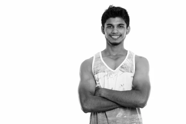 Studioaufnahme eines glücklichen jungen Inders, der mit verschränkten Armen lächelt — Stockfoto