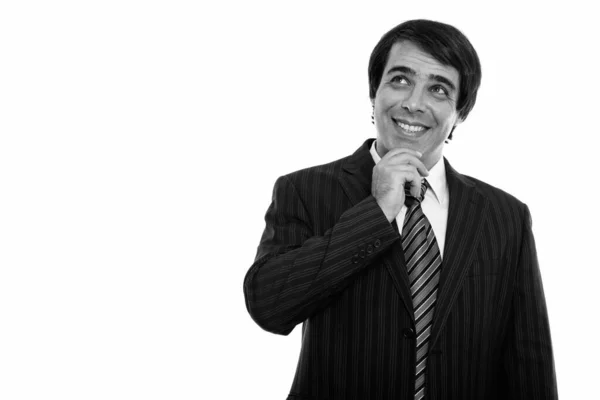 Studio shot of young happy Persian businessman smiling while thinking — Stock Photo, Image