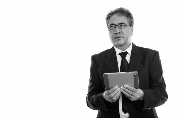 Plan studio d'un homme d'affaires persan tenant une tablette numérique tout en pensant — Photo