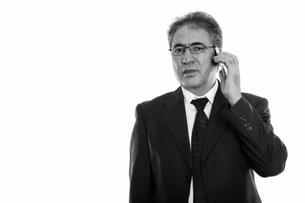 Estúdio tiro de empresário sênior persa falando no telefone celular — Fotografia de Stock