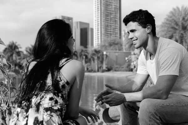 Jovem casal hispânico relaxando no parque juntos — Fotografia de Stock