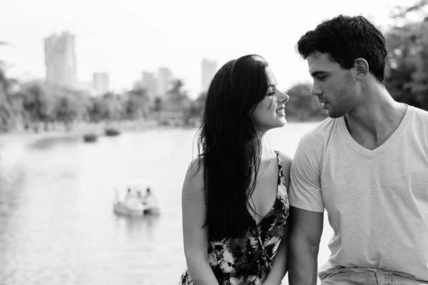 Jovem casal hispânico relaxando no parque juntos — Fotografia de Stock