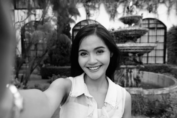 Joven hermosa mujer asiática tomando selfie mientras sonríe —  Fotos de Stock