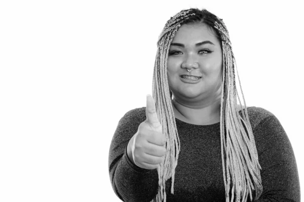 Studio skott av ung glad fet asiatisk kvinna ler samtidigt som tummen upp — Stockfoto
