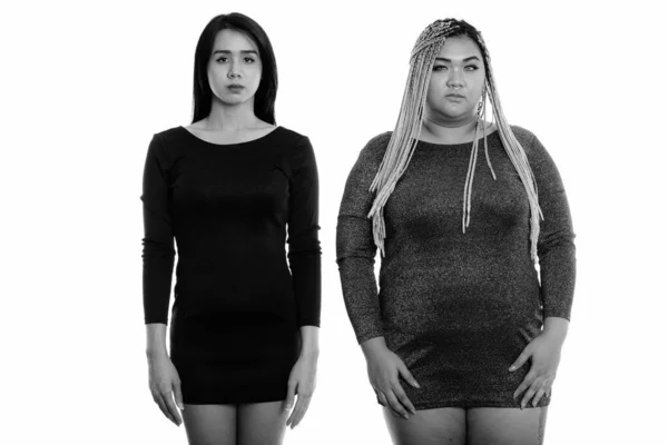 演播室拍摄的年轻的亚洲跨性别女性和肥胖的亚洲女性站在一起 — 图库照片