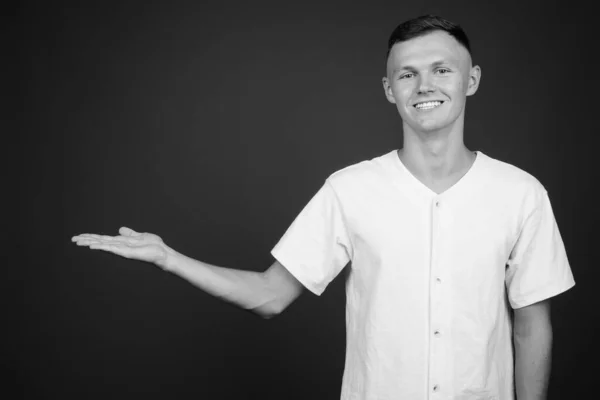 Jovem vestindo camisa branca contra fundo cinza — Fotografia de Stock