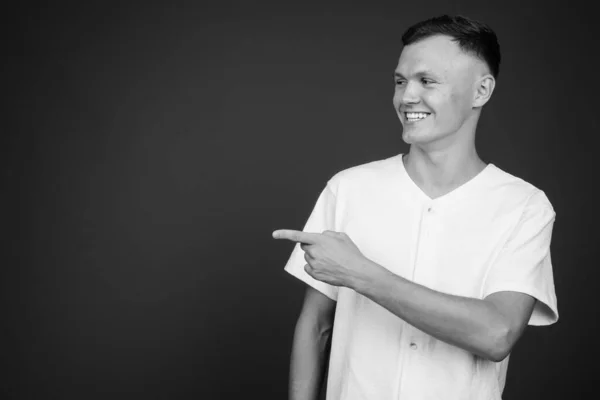 Hombre joven con camisa blanca sobre fondo gris — Foto de Stock